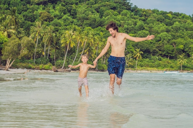 Papa speelt met zijn zoon in de zee