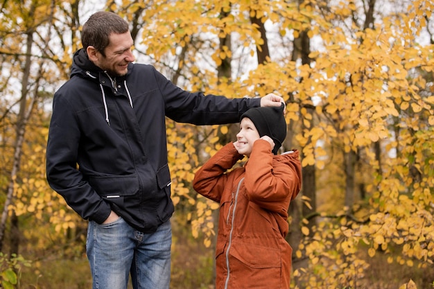 Papa speelt met zijn zoon in het herfstbos