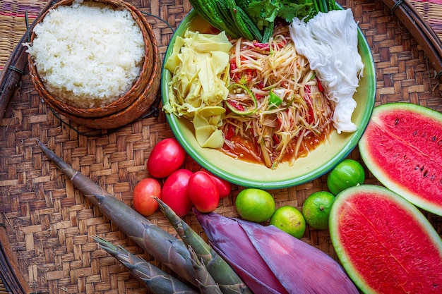 Papajasalade geserveerd op eettafel Groene papajasalade pittig thais eten op bord met verse groenten