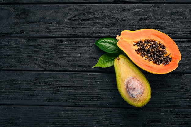 Papaya and avocado Fresh Tropical Fruits On a wooden background Top view Copy space