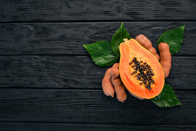 Papaya en ramboetan vers tropisch fruit op een houten achtergrond Bovenaanzicht Kopieer de ruimte