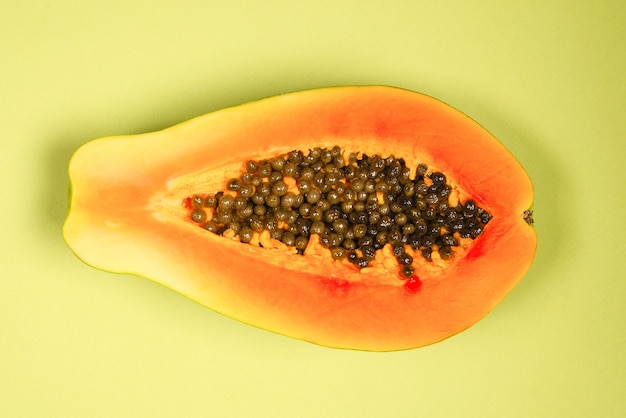 Foto frutto di papaia su uno sfondo verde. frutta tropicale. mezza papaia.