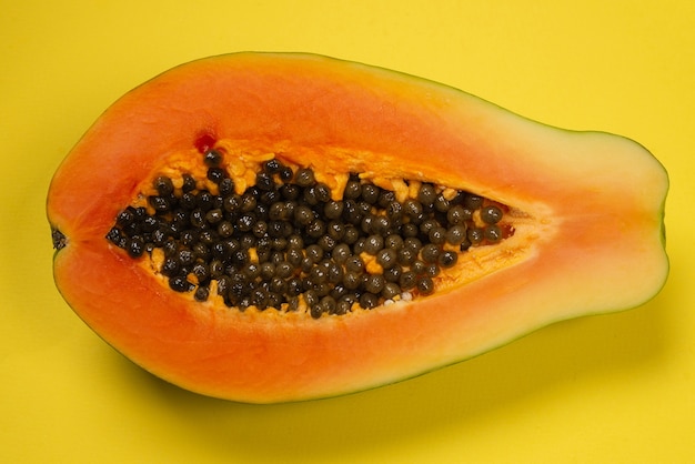 Papaya fruit op een gele achtergrond. Tropisch fruit. Halve papaja.