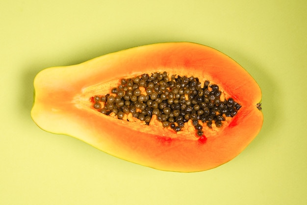 Papaya fruit op een groene achtergrond. Tropisch fruit. Halve papaja.