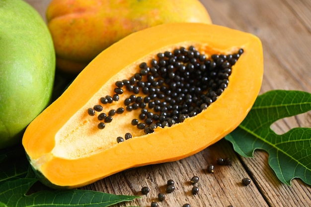 Papaya fruits on wooden backgroud fresh ripe papaya tropical\
fruit with papaya seed and leaf leaves from papaya tree