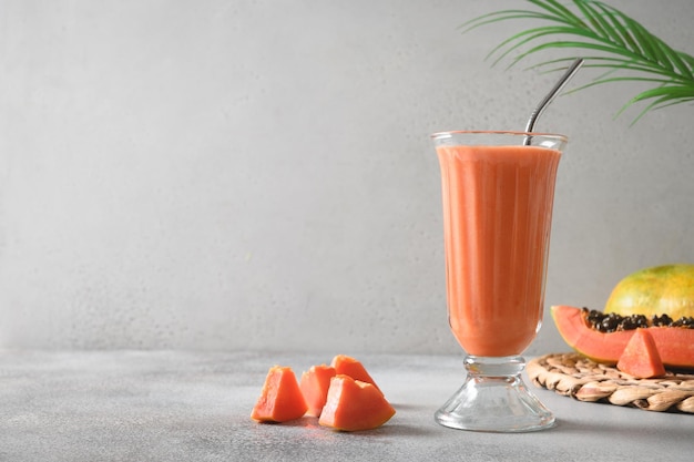 Papaya lassi in glass on gray background