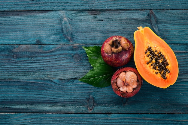 Papaya and mangosteen Tropical Fruits On a wooden background Top view Copy space