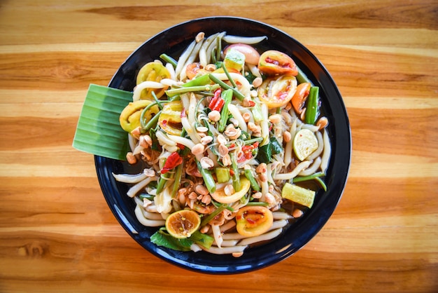 Photo papaya salad mix noodle vegetable and peanut served on table rice noodle salad spicy thai food