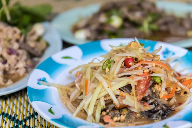 Papaya salad or Papaya Pok Pok (Som tum) for sale at Thai street food market or restaurant in Thaila