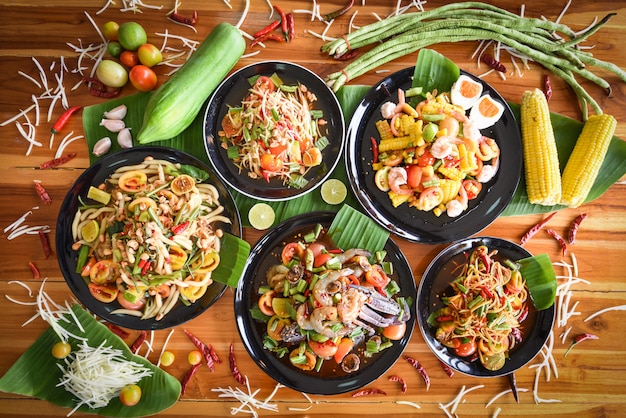 Фото Салат из папайи подается на обеденном столе. еда зеленого салата папапайи пряная тайская на плите с свежими овощами.