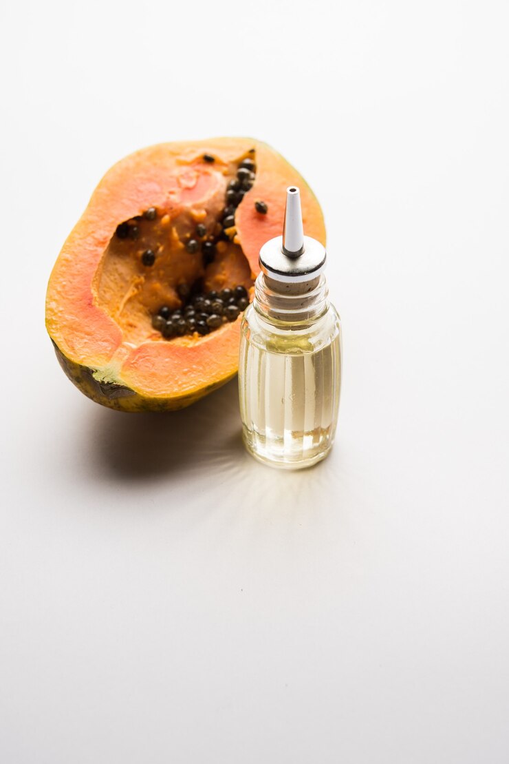 फोटो papaya seed oil with raw papita over moody surface. selective focus