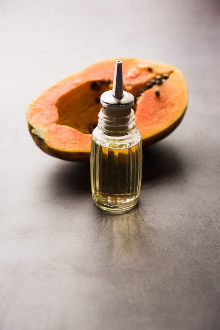 फोटो papaya seed oil with raw papita over moody surface. selective focus