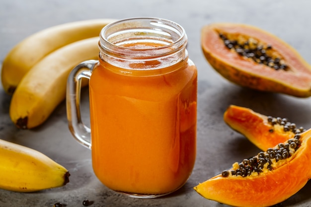 Papaya smoothie in a jar with papaya slices