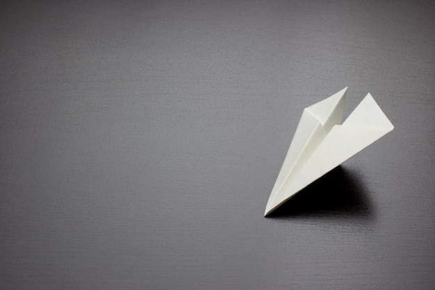 Paper air plane on dark background for design