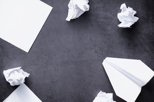 Paper airplane on the table. origami model on a dark\
background. concept. creative waste of time.