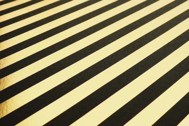 Paper background with black and gold diagonal foil stripes.