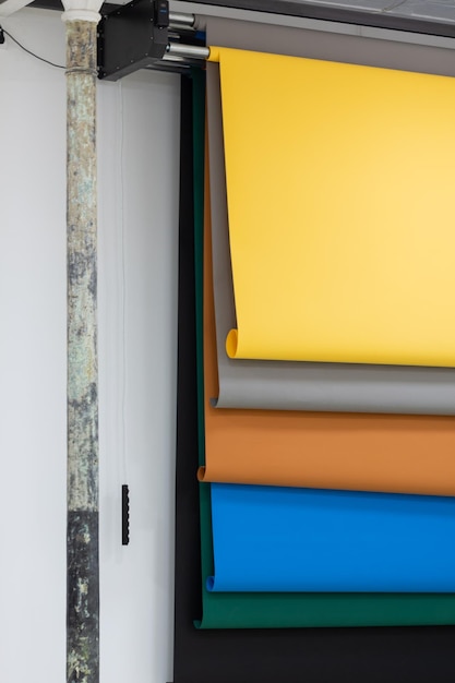 Paper backgrounds of multiple colors hanging on the wall on the automatic system