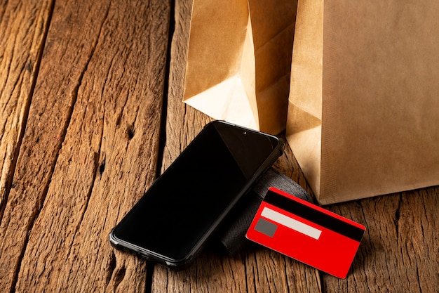 Paper bag, smartphone, wallet and credit card. Black Friday.