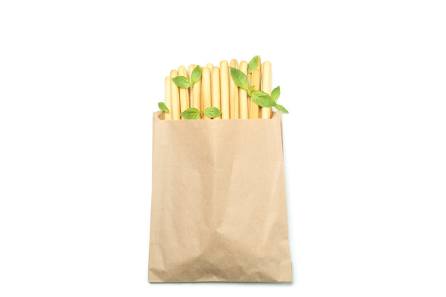 Paper bag with grissini breadsticks isolated on white