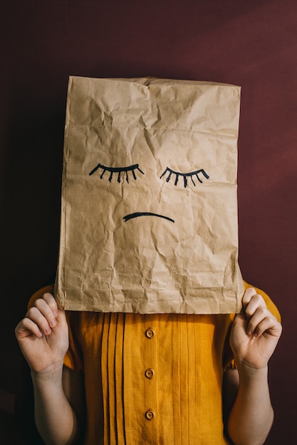 Paper bag with a sad face instead of a child's head