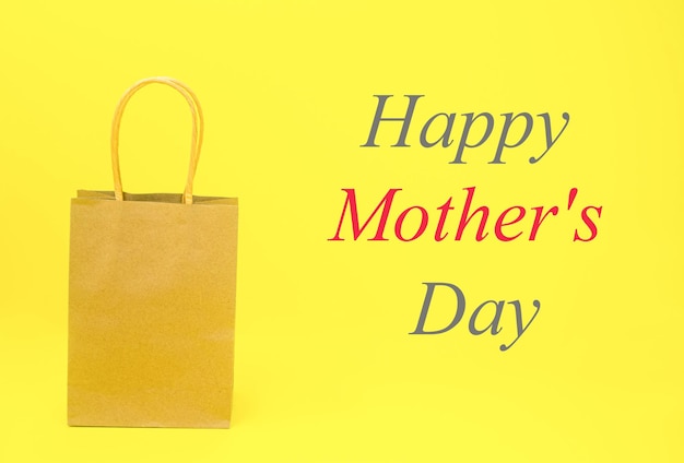 A paper bag with the words Happy Mother's Day in large letters on a yellow background