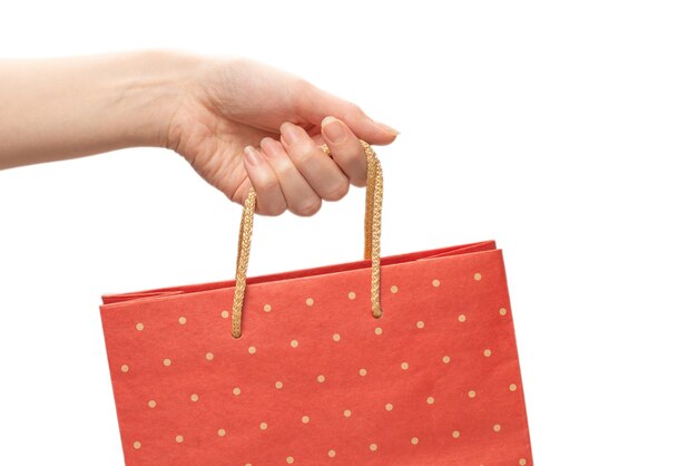 Paper bag in woman hands isolated on white background.