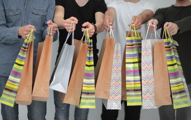 Photo paper bags in the hands of a team of friendsthe concept of shopping