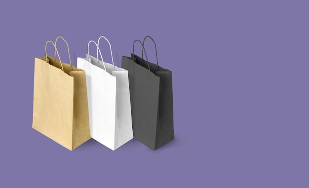 Paper bags for shopping on violet background Copy space