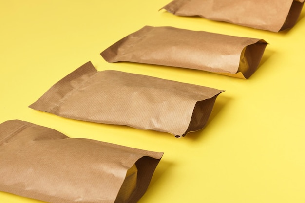 黄色の背景パターンの紙袋環境にやさしい包装、紙のリサイクル、ゼロウェイスト、自然製品のコンセプト。スペースをコピーします。