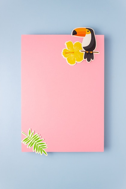 Paper bird and palm tree branch on blank pink card or note. Minimal concept.