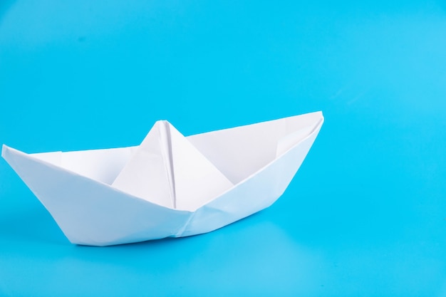 Paper boat on a blue background. Faith symbol, hope.