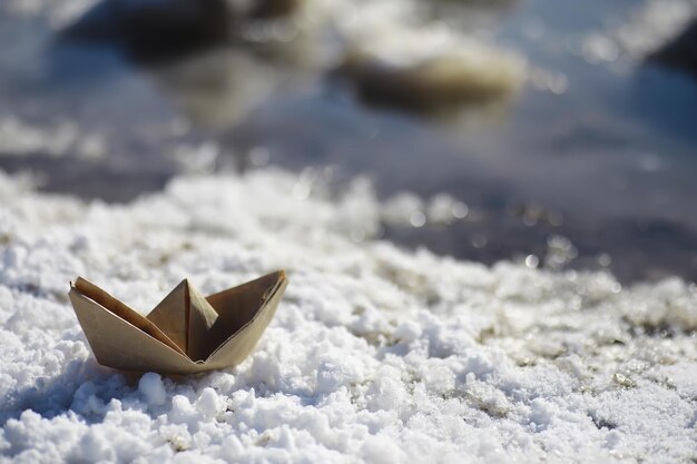 通りの水の中の紙の船。早春のコンセプト。雪解けと水の波で折り紙のボート。