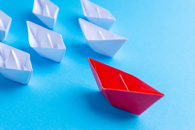 Paper boats over blue background