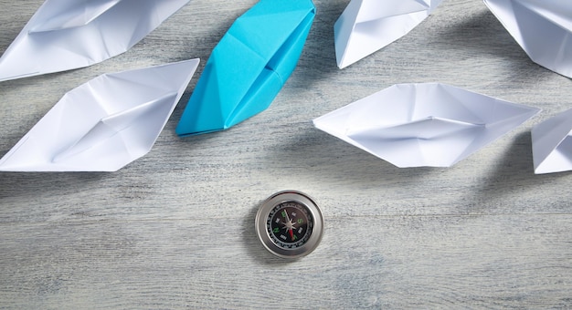 Paper boats with a compass Business concept