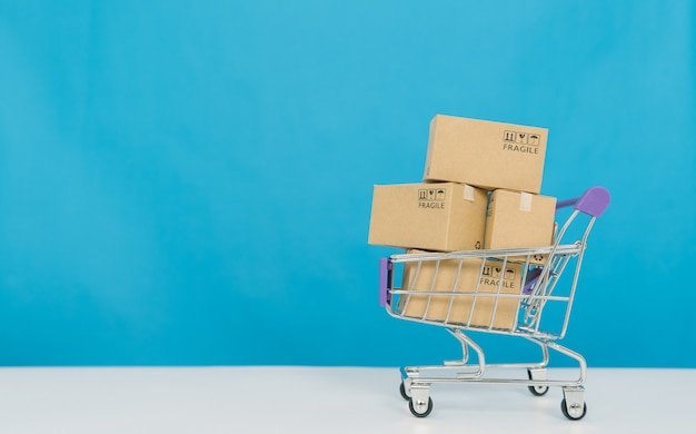 Paper boxes in a trolley on blue background