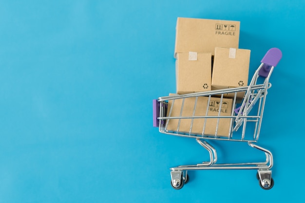 Paper boxes in a trolley on blue background