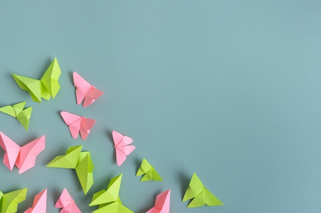 Photo paper butterfies green and pink color flat lay on a colored background lightness spring beauty concept