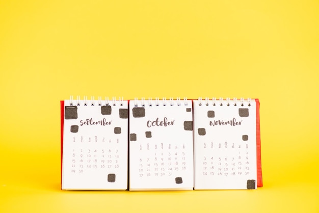 Paper calendar with september october and november months on yellow background