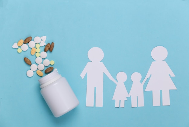 Paper chain family, bottle pills on blue, health insurance concept