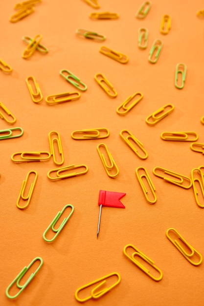 Paper clips closeup on orange background. Office stationery supplies, school or education accessories, writing and drawing tools