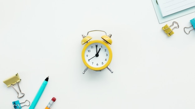 Paper clips, mechanical clock, pen, pencil and notepad on white background. Work and education concept.