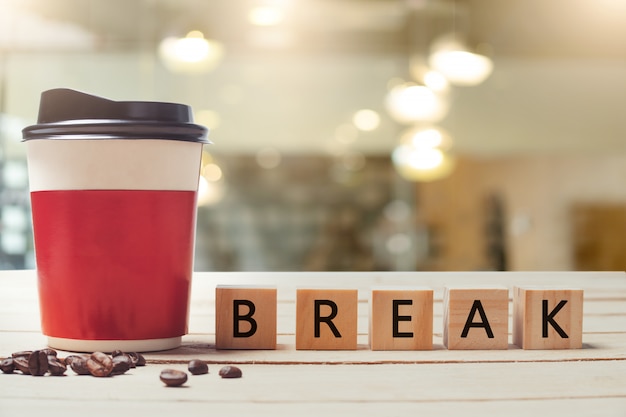 Photo paper coffee cup and  break wood letter with blurred coffee shop