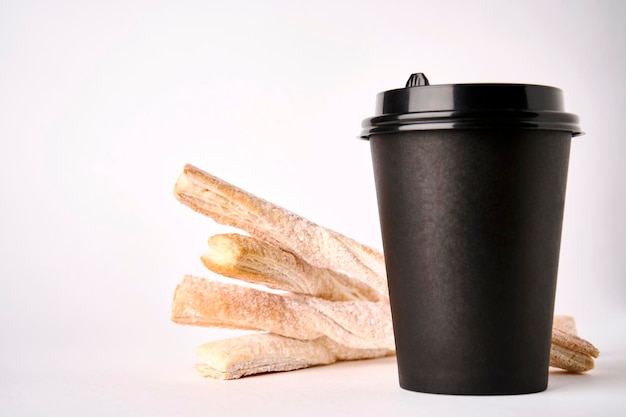 Paper coffee cup and Puff pastry sticks closeup