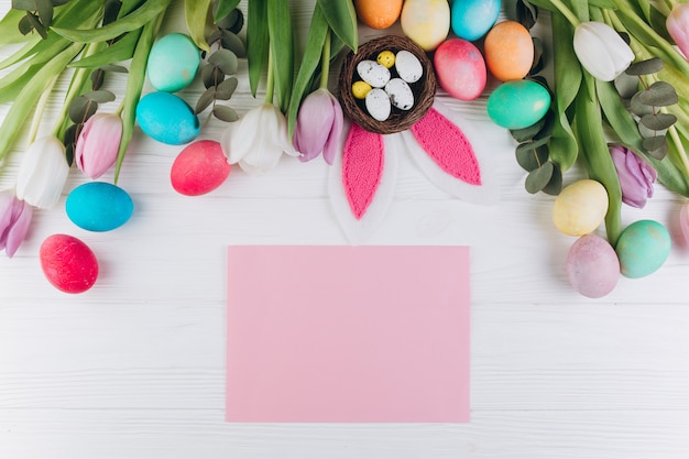 Paper colored eggs, rabbit ears, nest and tulips