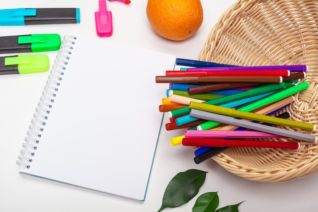 paper and colorful felt tip pens on the white table