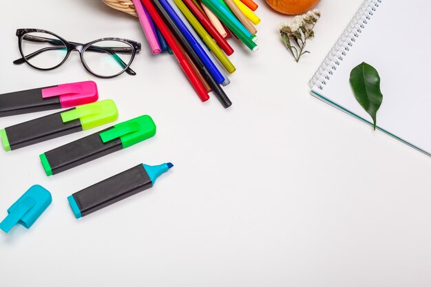 paper and colorful felt tip pens on the white table