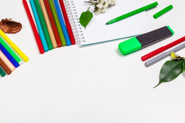 paper and colorful felt tip pens on the white table