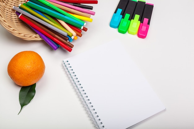 Paper and colorful felt tip pens on white table