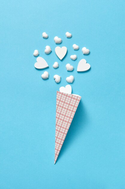 Paper cone with small white gypsum hearts as ice-cream sweet dessert