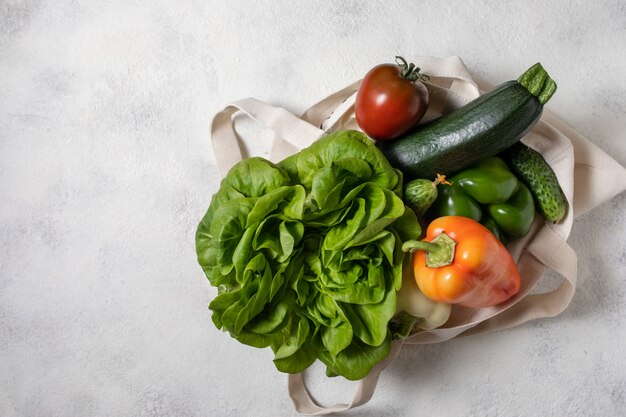 健康的な野菜の紙と綿の袋、テーブルの上に平らな食品。トップビュー、コピースペース。